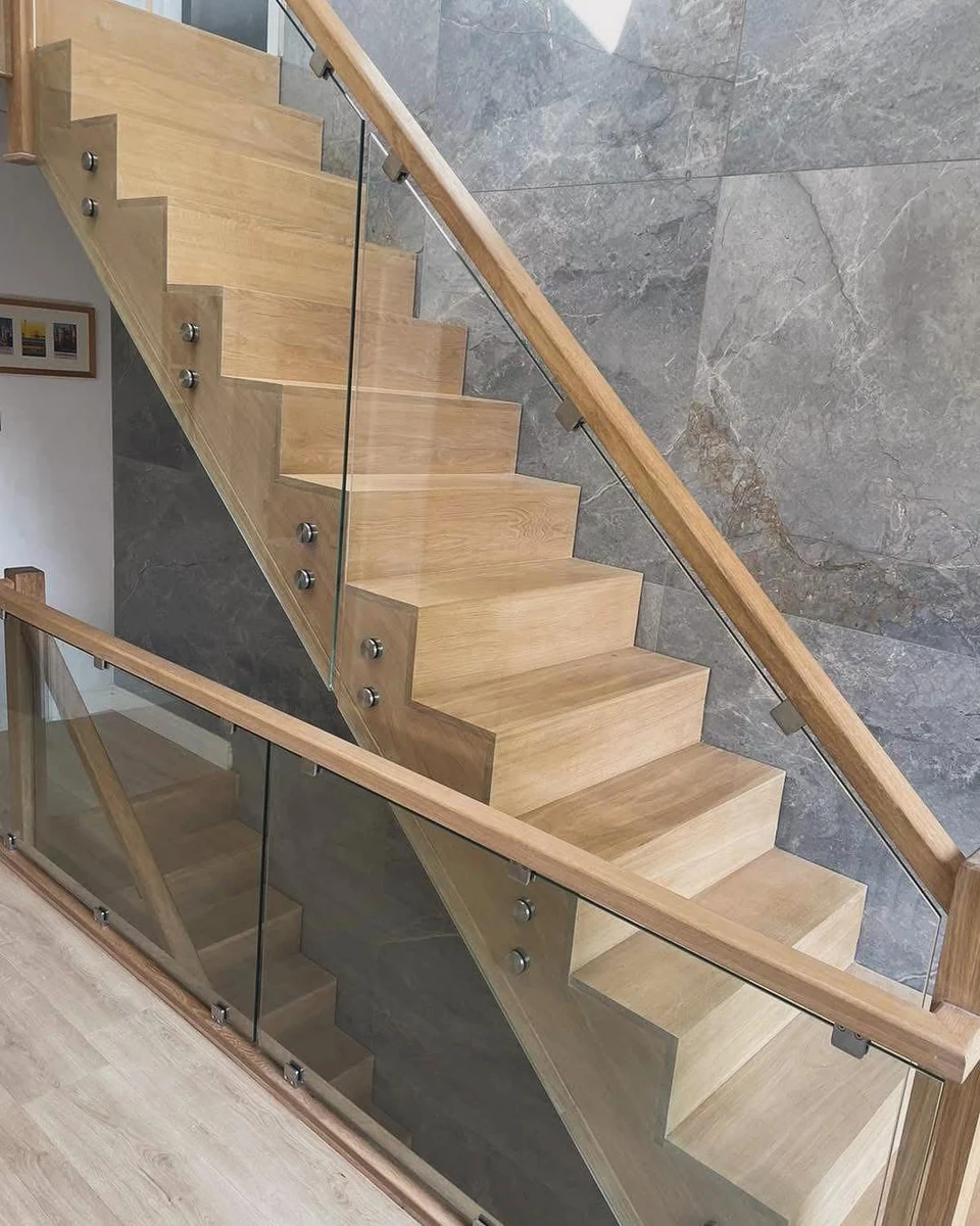 Frameless glass balustrade with oak handrail on marble landing, Sevenoaks Glass Balustrades